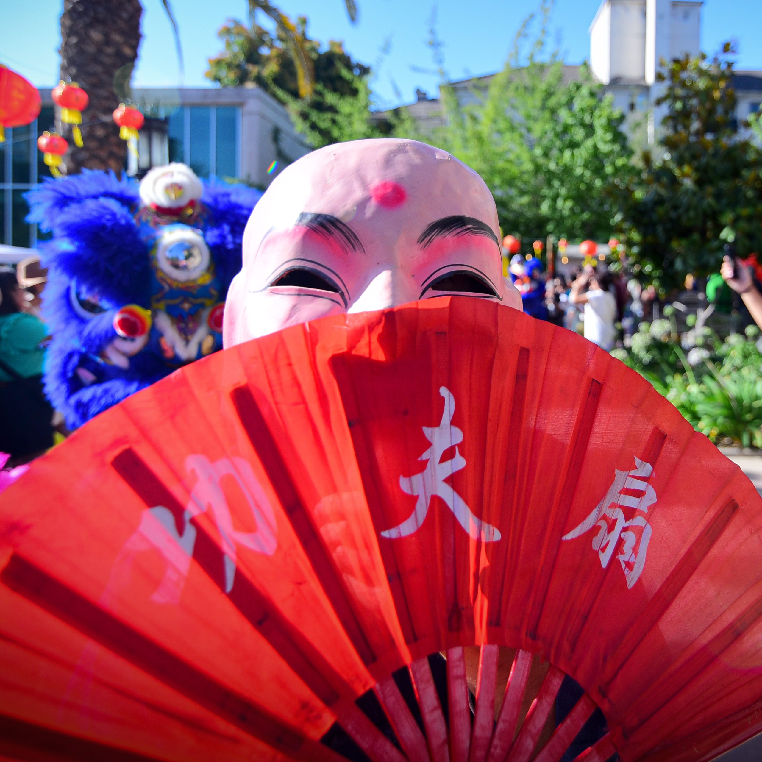 Persona con una máscara y abanico en la celebración del año nuevo chino en Providencia.